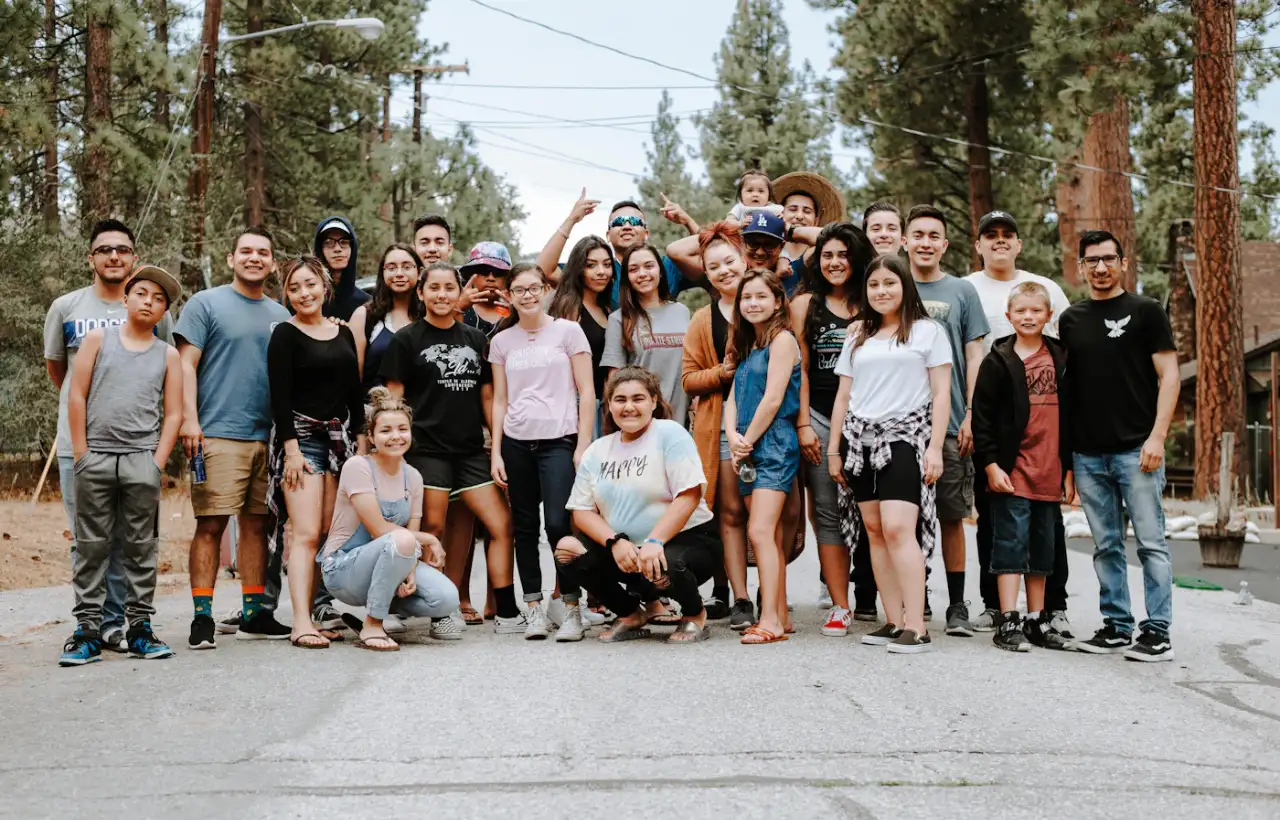 A large group of young people and adults posing together outdoors